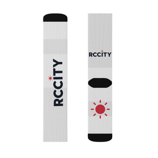Two white socks with black and red branding