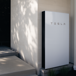Tesla Powerwall 2 13.5 kWh battery installed on outdoor wall for home energy savings