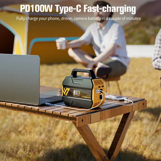 Portable power station charging laptop and phone outdoors.