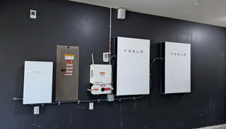 Tesla battery units mounted on a dark wall